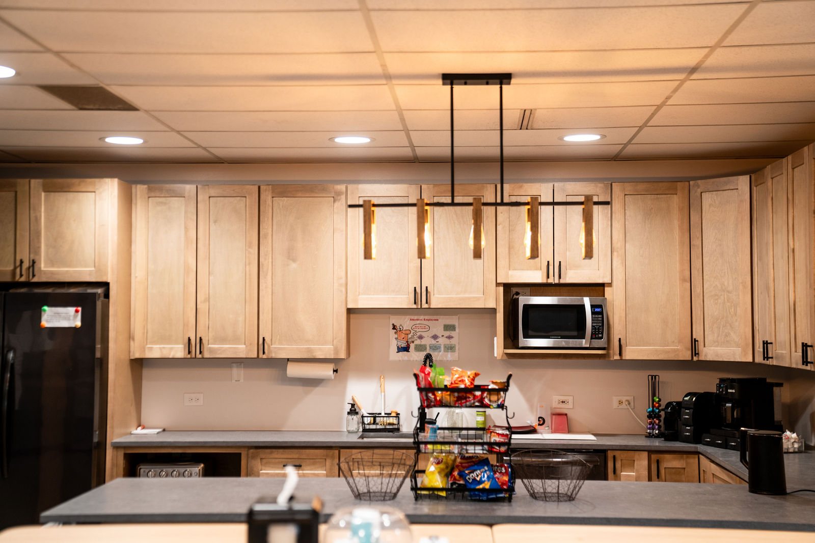Shared kitchen with pendant lighting and cabinetry