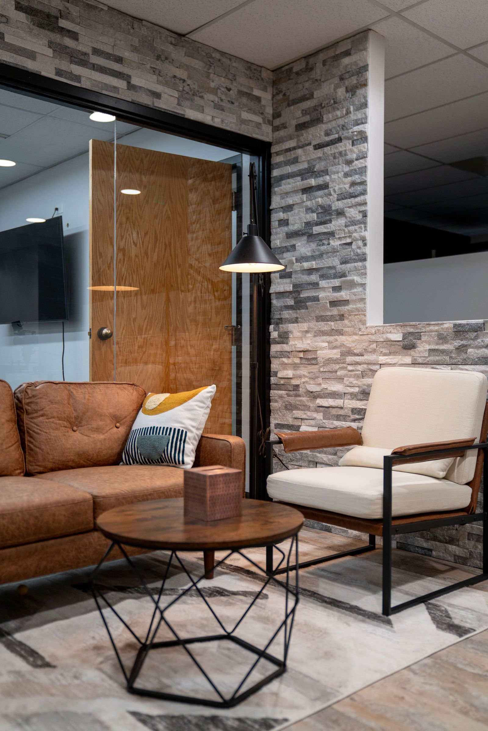 Wing chairs and side table in a stone-walled nook