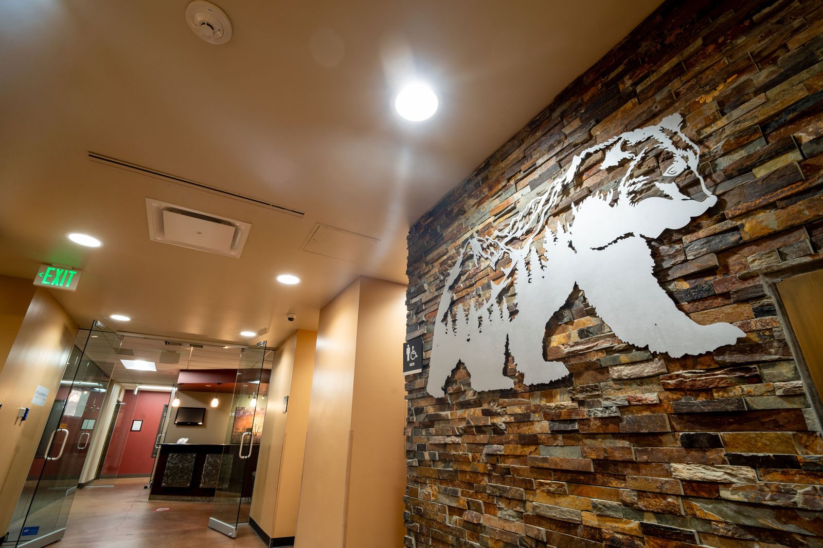 Elevator lobby with stone wall and bear artwork