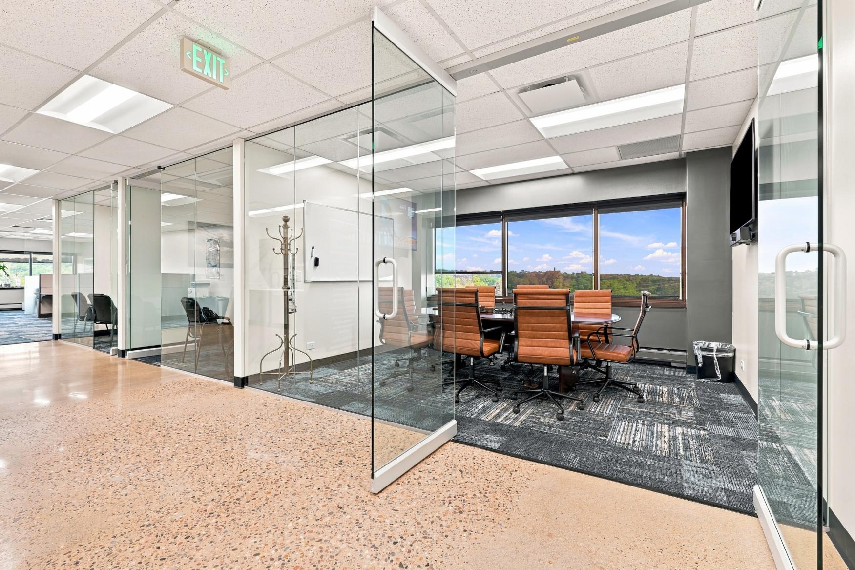 Glass-walled conference rooms along a daylit corridor at Bear Valley Center