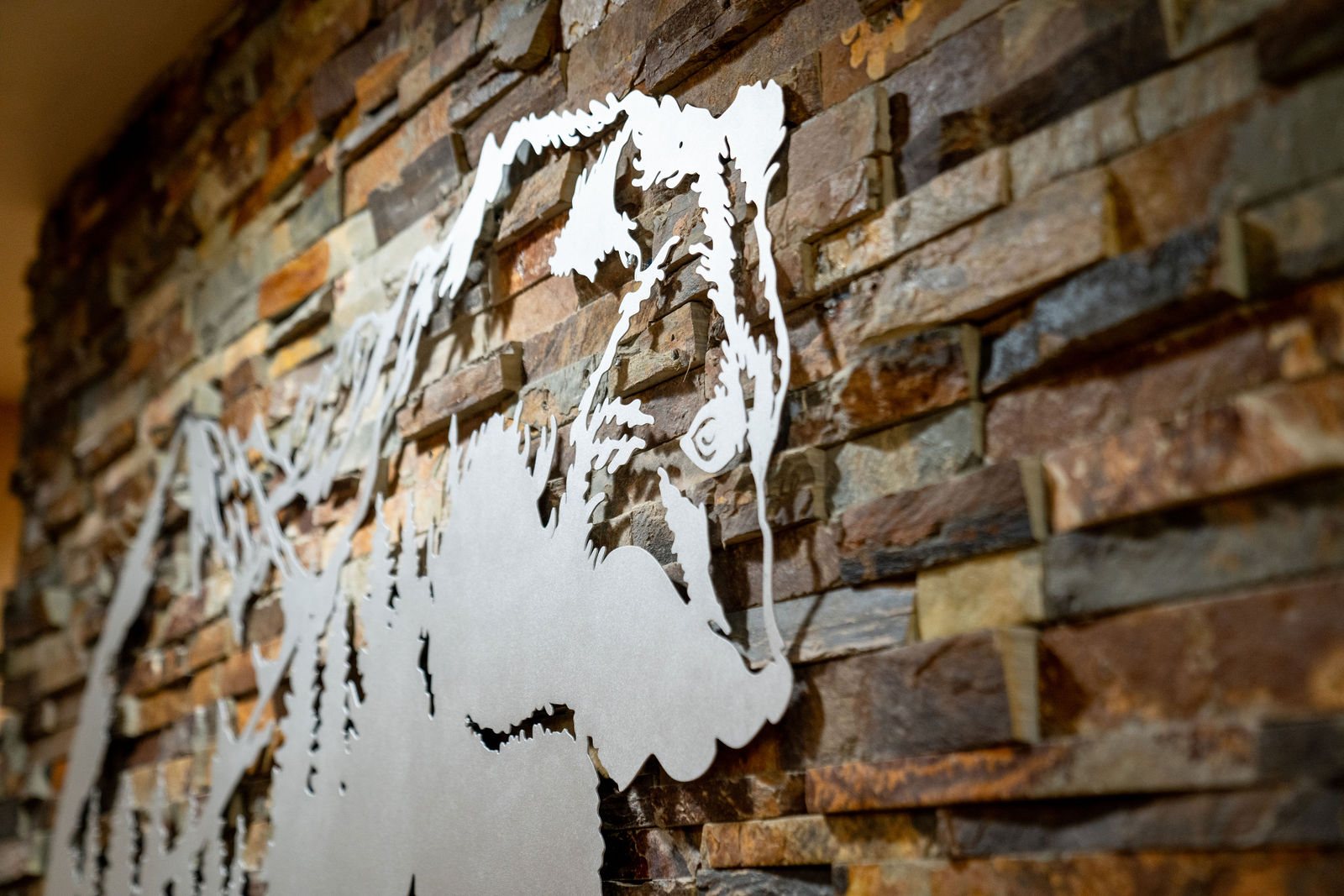 Close detail of metal bear artwork on stone