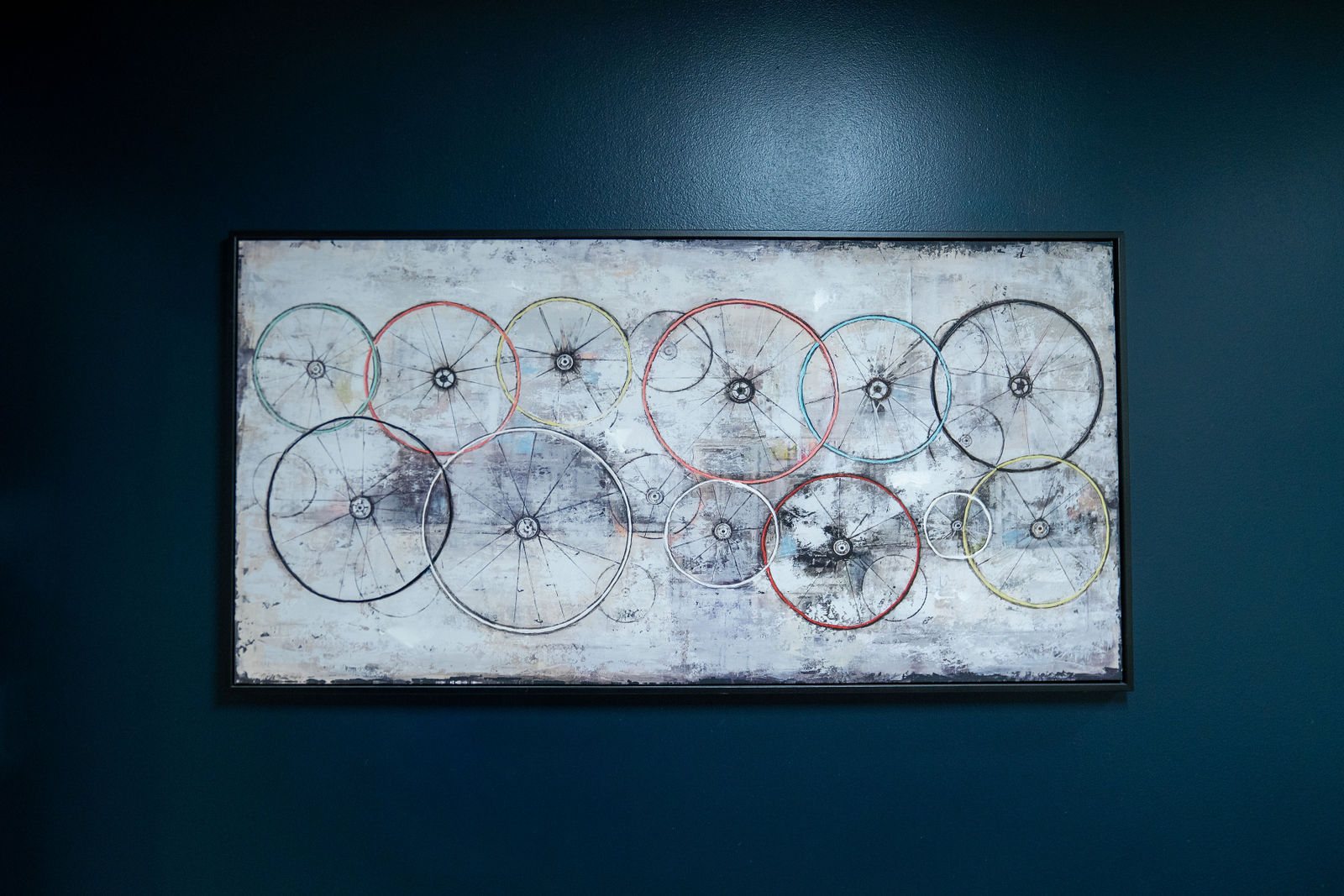 Framed bicycle wheel artwork on a dark wall