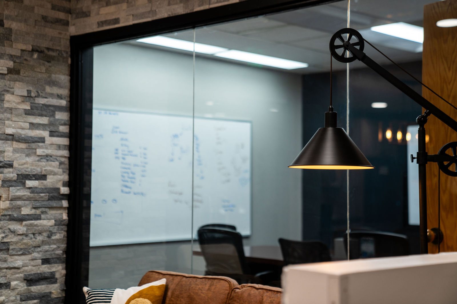 Glass-walled meeting room beside stacked stone